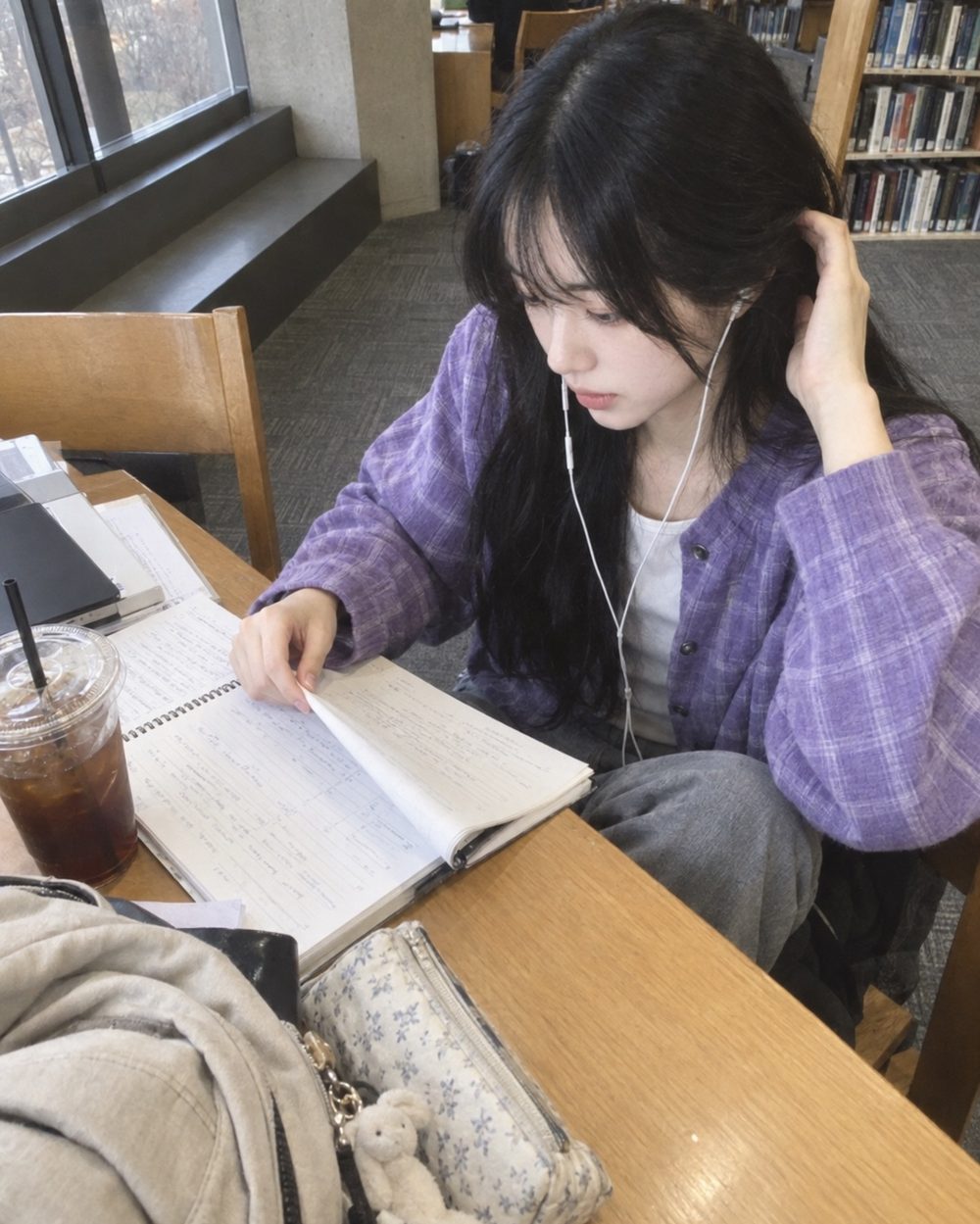 도서관 창가 책상에서 공부하는 하은